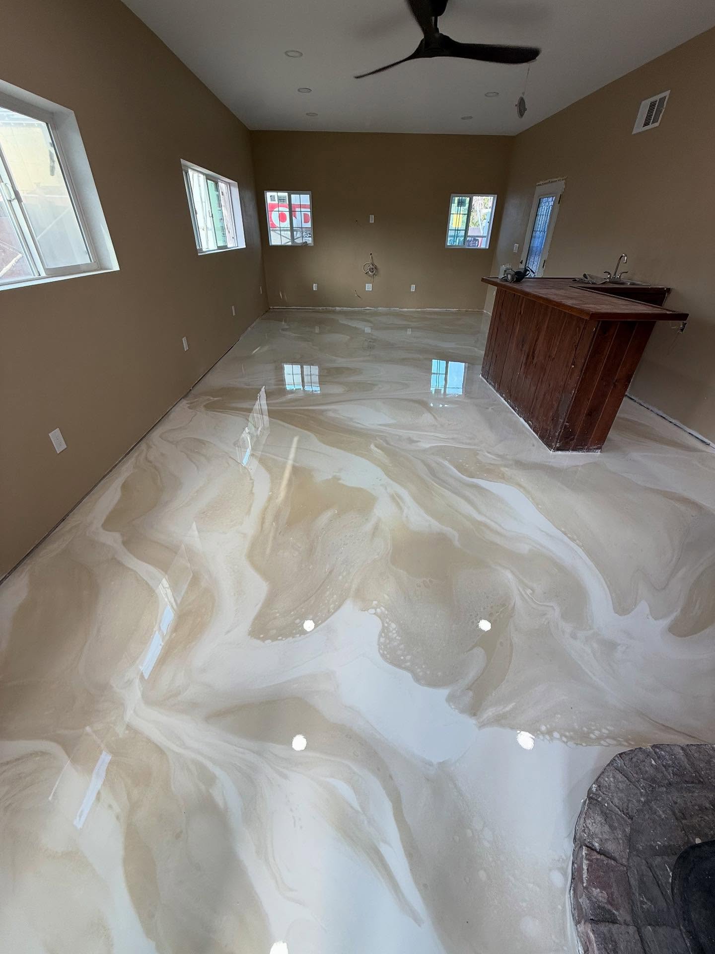 Cream and pearl metallic epoxy floor across a Los Angeles residential living space with wet bar