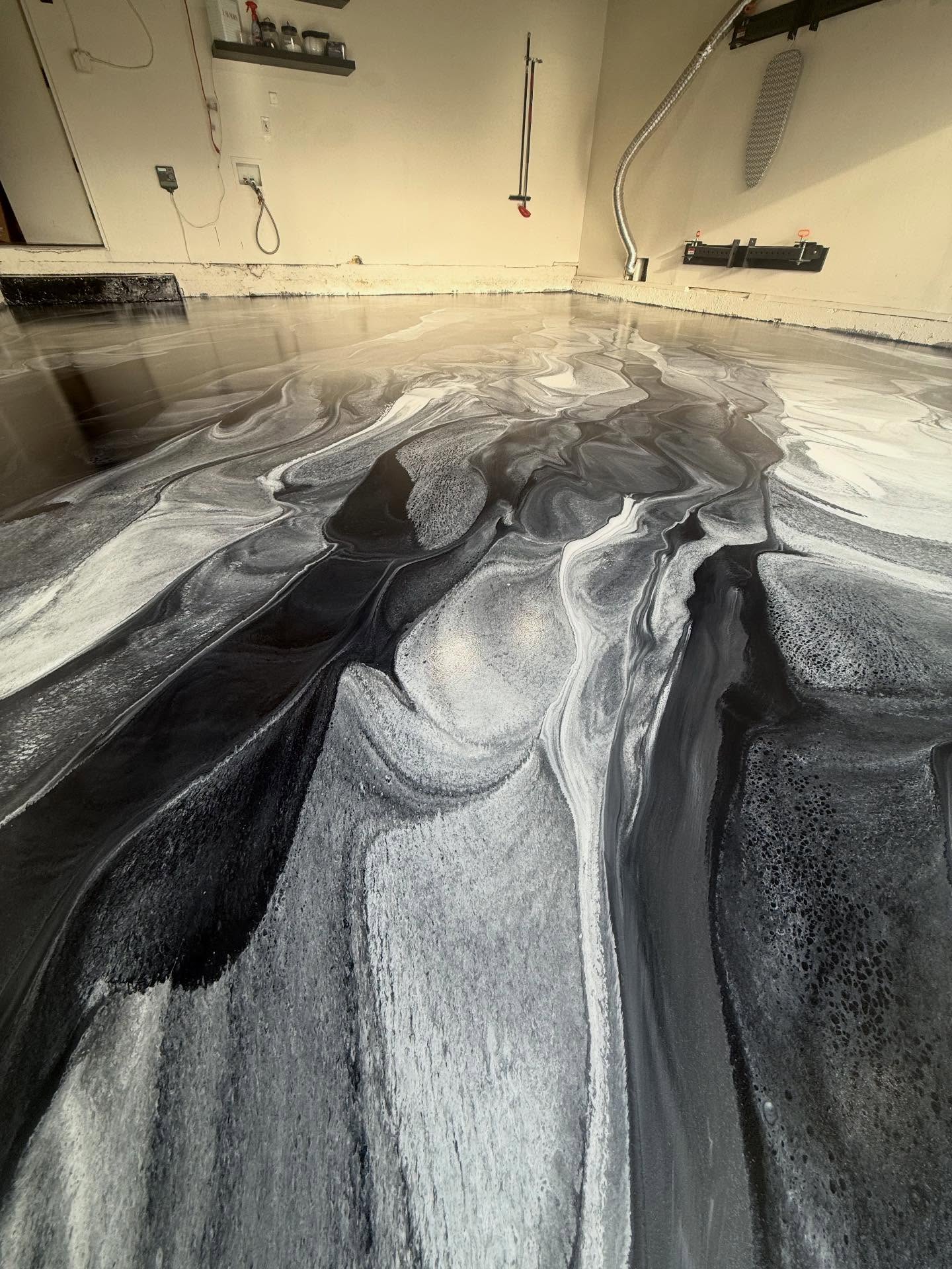 Dramatic black and silver metallic epoxy floor in a Los Angeles installation, deep pewter waves with mirror-gloss finish